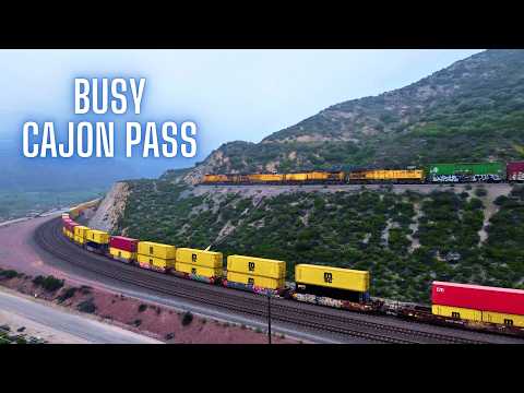 A Stormy Day in The CAJON PASS - 3 Trains Race! & A Heavy Rock Train Crawls Down the GRADE