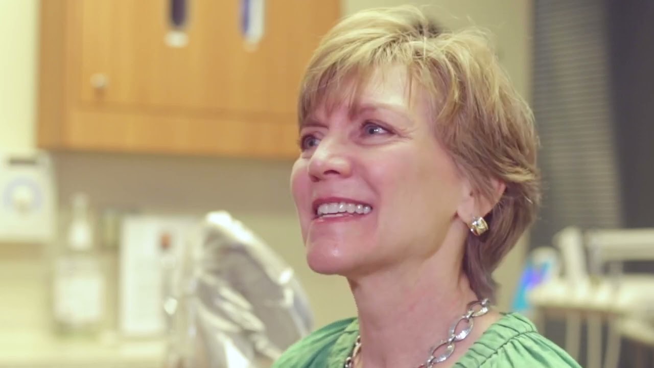 Woman wearing green blouse in Atlanta dental office