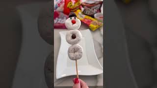 Make the cutest edible snowmen out of powdered donuts and candies! #holidaysnacks #christmassnacks