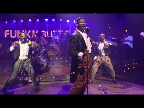 Five Guys Named Moe revival trailer still: the five Moes in bright plaid suits on bandstand