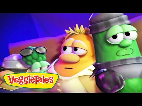 VeggieTales scene with cartoon vegetable characters on a colorful stage and the VeggieTales logo in the bottom-left corner.