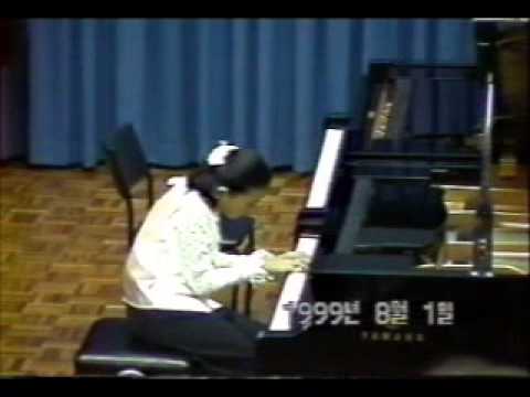 Dami playing piano at age 10