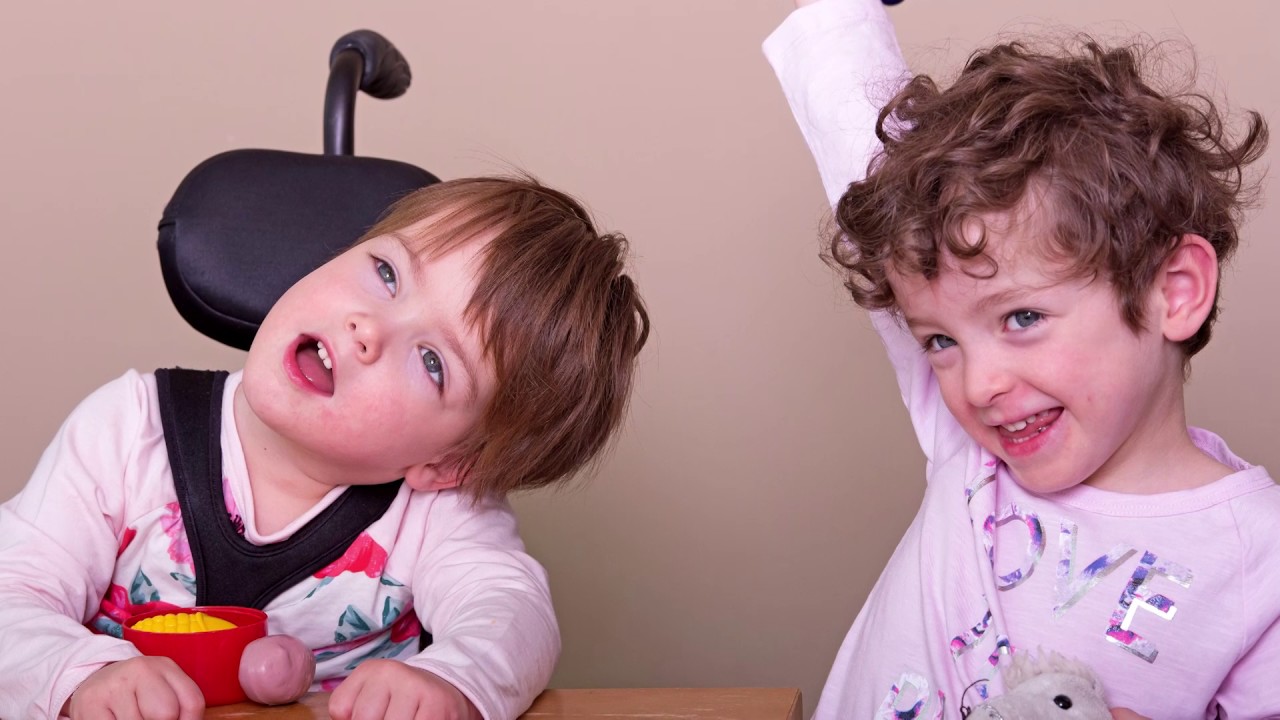 Cora in her wheelchair alongside her twin sister Beatrice