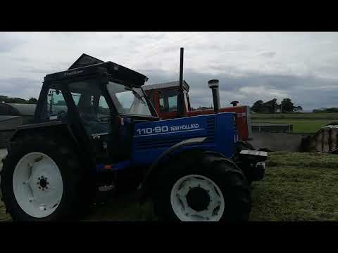 The newholland 110 90 rolling the silage pit with the massey ferguson 1155 v8