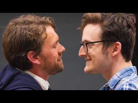 Soho Cinders trailer frame: neon Soho street as the ensemble launches into a brassy opener