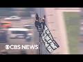 2 People Climb To Top Of Empire State Building And Fly Banner