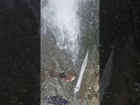 Standing behind waterfall