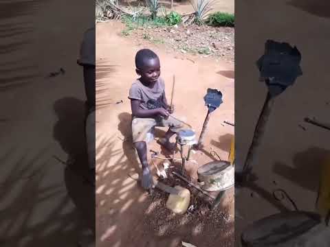 Little boy plays his homemade drum set.