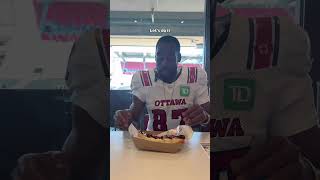 REDBLACKS WR Geno Lewis tries the Double Blue hotdog