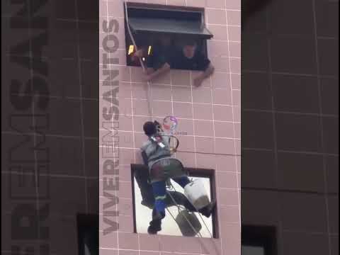 Trabalhadores ficam pendurados em fachada de prédio durante ventania em Santos.
