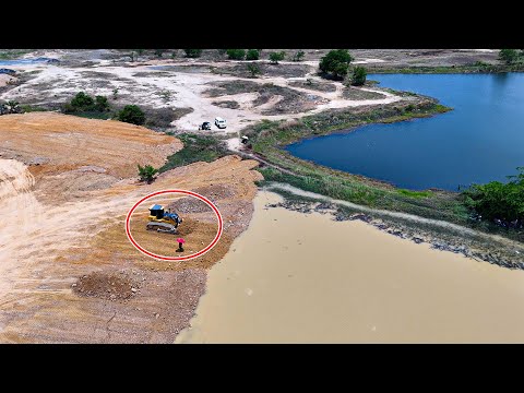 Amazing bulldozer SHANTUI DH17-C3 pushing soil filling dirt over water with dump trucks
