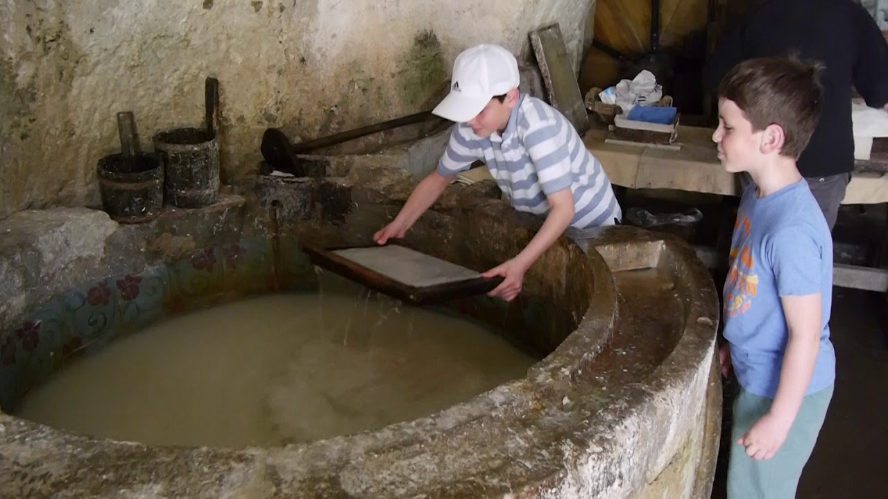 Children joyfully immersed in the art of paper creation at the paper mill.