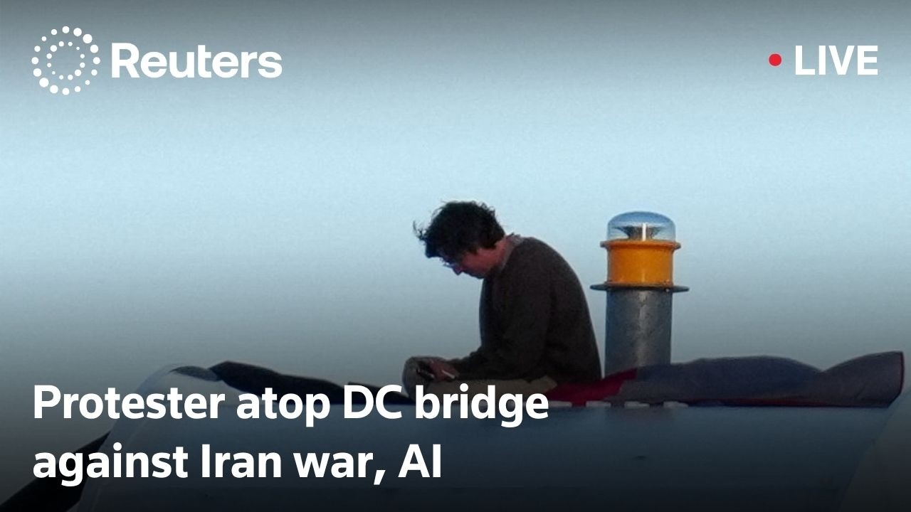 Video | LIVE: Protester atop DC bridge over Iran war, AI