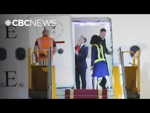 French President Emmanuel Macron pushed in the face as he prepares to deplane