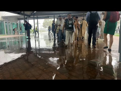 COP30 attendees navigate flooded corridors during heavy rainfall at climate conference venue | AFP