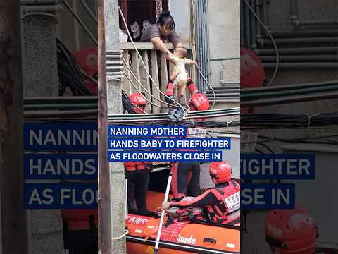 Nanning mother hands baby to firefighter as floodwaters close in