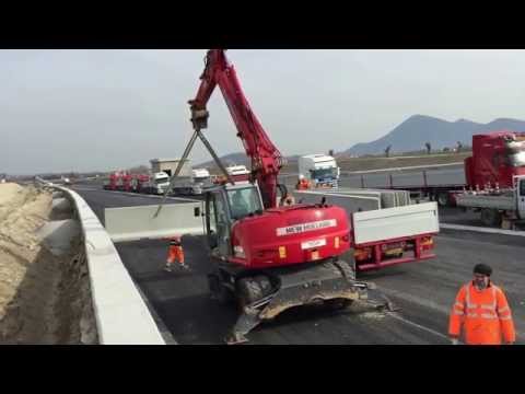 ESCAVATORE GOMMATO MH CITY AL LAVORO IN AUTOSTRADA