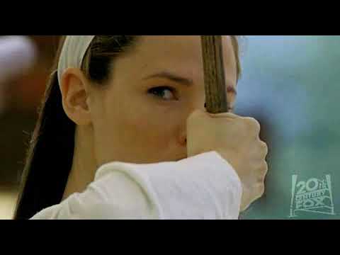 Elektra (2005) trailer frame: Jennifer Garner in red with twin sai in a shadowed corridor