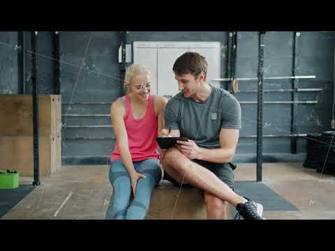 Man professional instructor talking to young woman and writing in chart relaxing after training