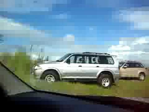 Rental car on the beach, big puddles.