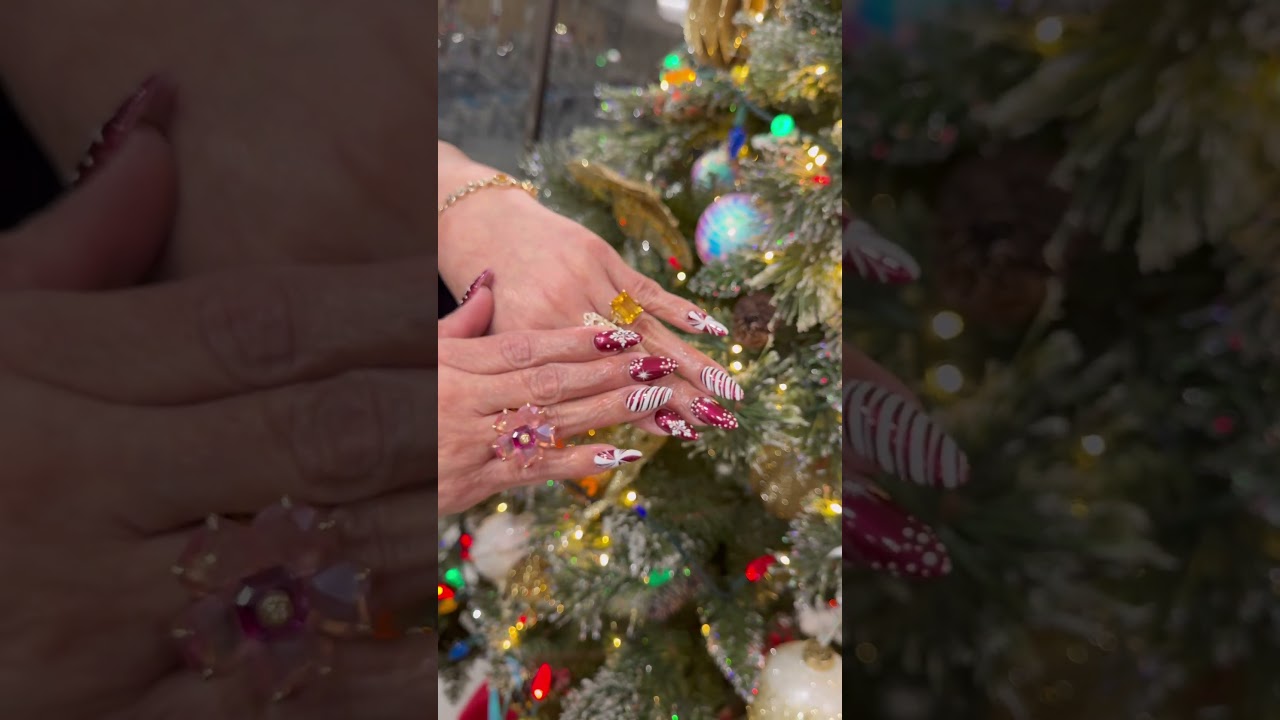 This nail design features red tones with Christmas candy accents