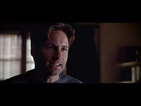 1998 trailer frame for The X-Files: Fight the Future with Mulder and Scully lit by flashlight beams
