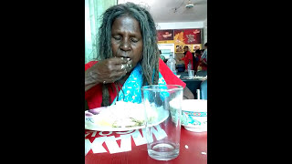 Homeless hungry woman having lunch  with pleasure.