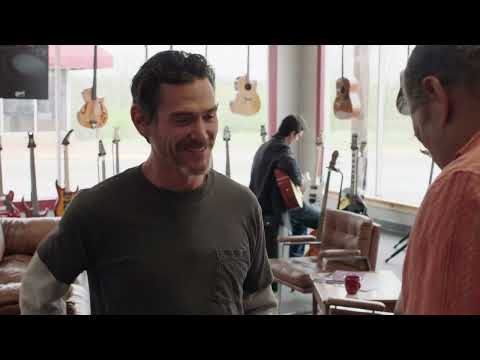 Rudderless official trailer still — Sam onstage at the bar’s open mic, guitar in hand