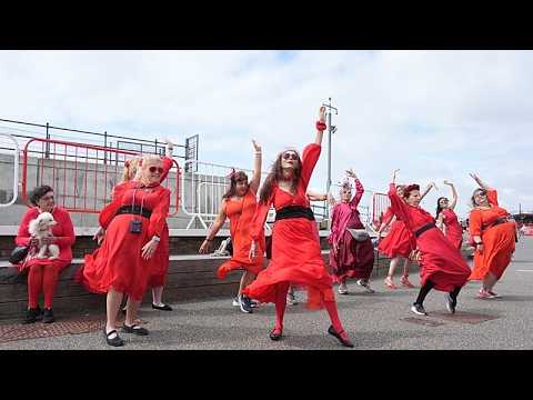 Video Thumbnail: Hunderte in Rot tanzen Kate Bushs „Wuthering Heights“-Choreografie nach