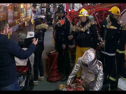 1970s Firemans Uniform With Yellow Cork Helmet Nomex Fire Tunic And The Iconic Yellow Waterproof Overtrousers mannequin-man performming as a Museum Dummy: The Essex Fire Museum added some christmas decorations to the historic firefighter uniform dispolay for Essex Fire Museum on 17/12/2023