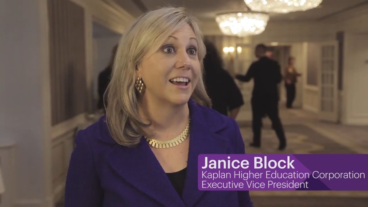 Woman in a purple blazer smiling, speaking on camera, with blurred figures in the background, promoting video marketing for law firms.