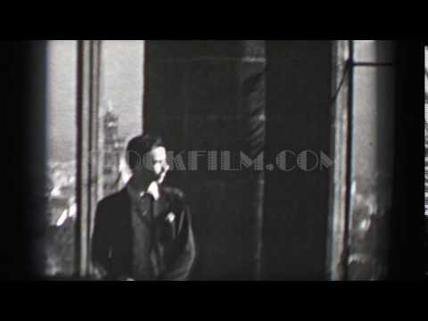 1937: Acrophobia fear of heights man in cathedral overlooking medieval German town. HAMBURG, GERMANY