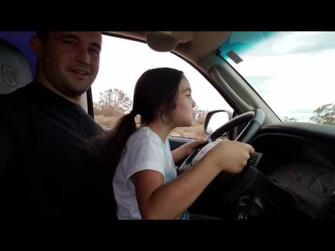 Daddy teaching his little girl how to drive. 