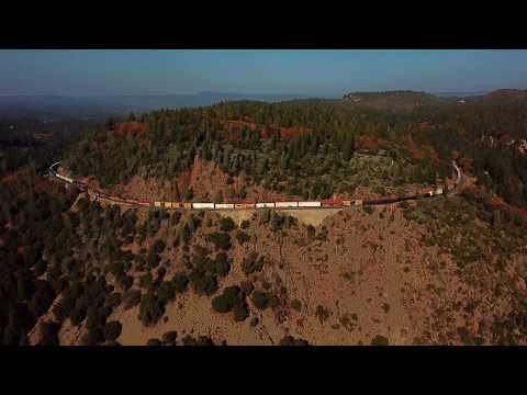 4K: Aerial footage of Union Pacific mixed freight train curves around Cape Horn, CA