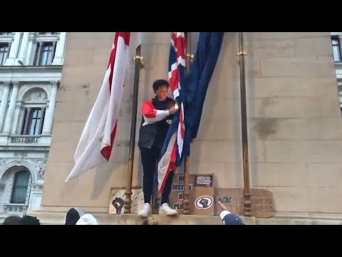 Protester appears to try to set a Union Jack on fire in London