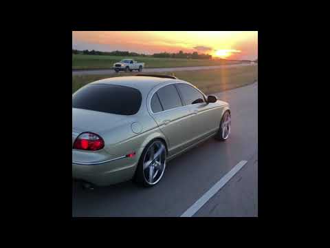 Jaguar S type on the freeway on 22” lexani R—4 Rims
