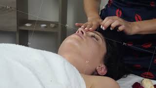 Young attractive cute brunette woman gets face massage in spa salon