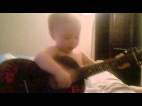 Xavier holding and playing the guitar!