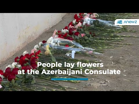 People lay flowers at the Azerbaijani Consulate in Aktau for plane crash victims