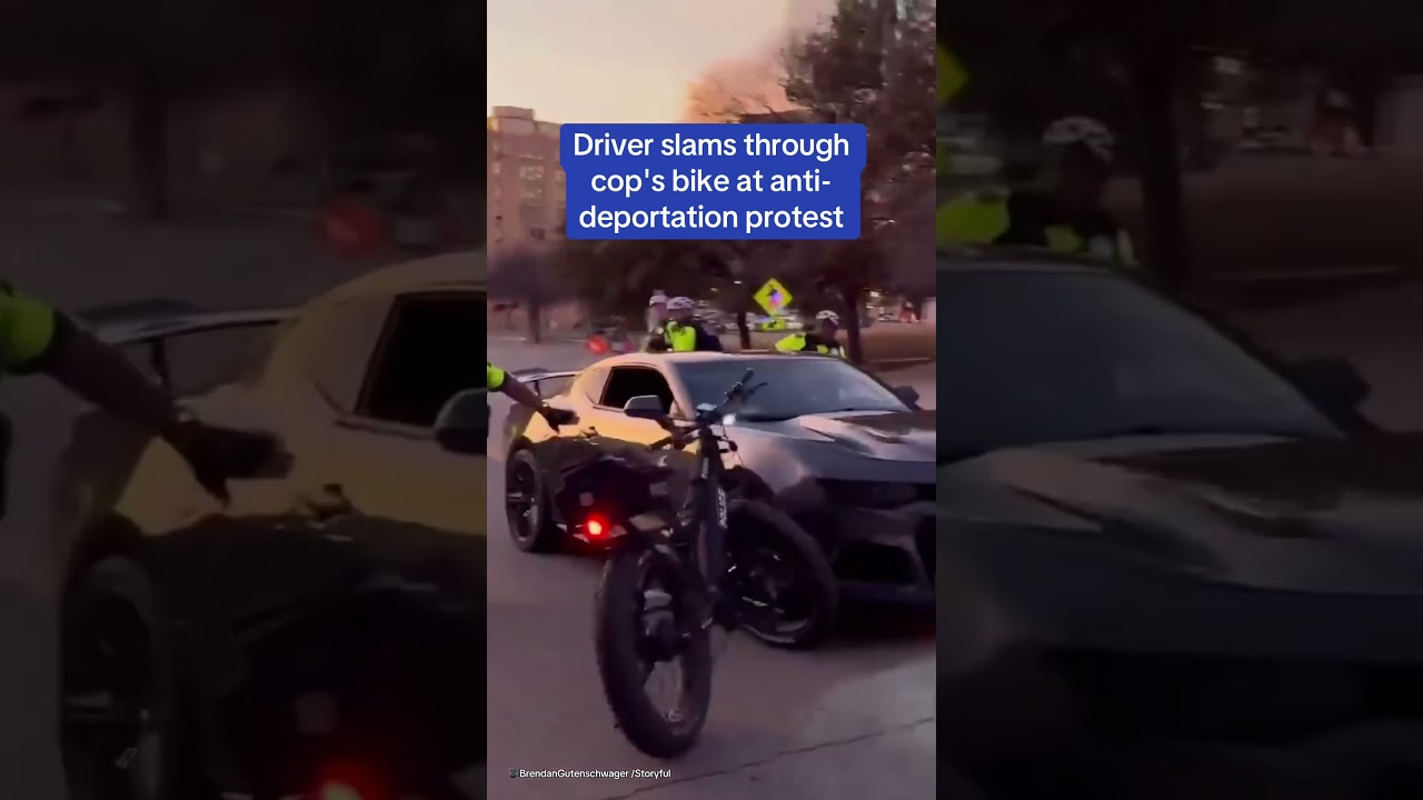 Driver slams through cop's bike at anti-deportation protest