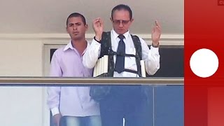 Brazil hostage taking: footage shows hotel employee with explosive vest, gun at head