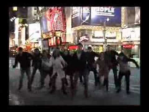 Trailer frame: ensemble bursts into a street-corner musical number in Manhattan