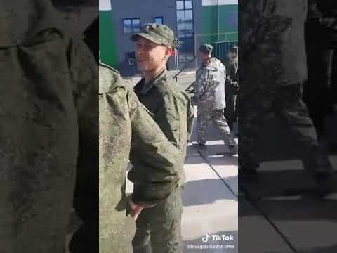 Russian conscript in a lineup with a bottle of vodka.