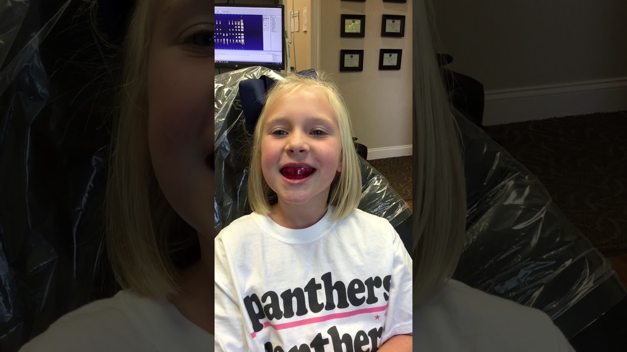 Blonde girl in dental chair wearing oral appliance over her teeth