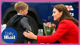 Kate Middleton wooed by young boy with flowers, Prince William stands behind