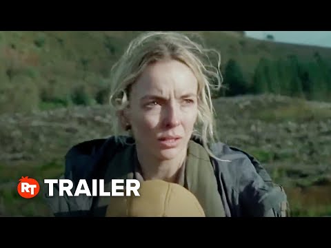 Trailer frame: rain-smeared window and a cradle silhouette as the score’s pulsing electronics rise