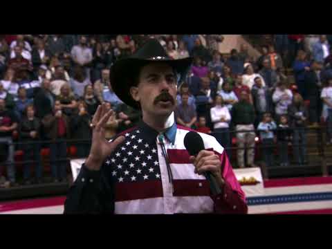 Borat (2006) trailer thumbnail featuring Sacha Baron Cohen in gray suit waving a small flag