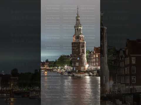 City panorama of Amsterdam night timelapse featuring the Montelbaanstoren tower. Netherlands
