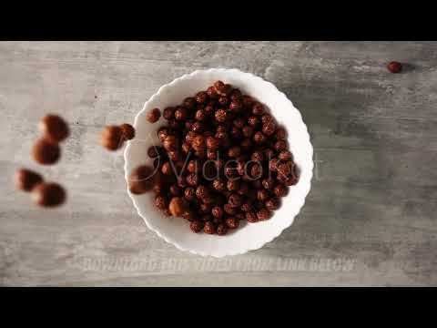 Large amount of cornflakes in form of brown chocolate balls is poured onto plate for quick breakfast