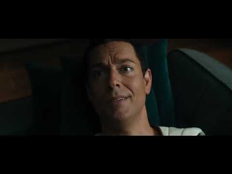 Trailer moment with Shazam facing off amid blue lightning; end-credit style typography overlay